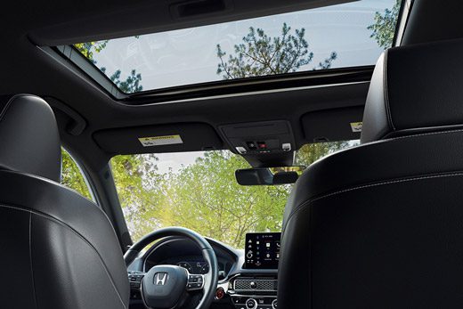 2026 Honda Civic Sedan Sport Touring Hybrid interior view from rear seat showing moonroof and dashboard