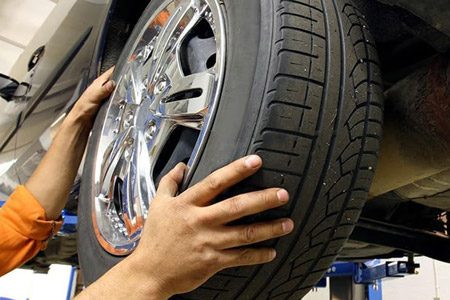 A mechanic is rotating car tires
