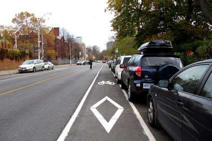 One side of the straight road was filled with parked cars