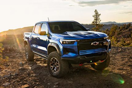 Three Quarters View of a Black 2026 Chevy Colorado Pickup Truck Going Down a Rocky Road