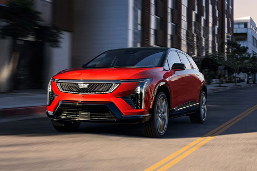 Three-quarter view of the front side of a 2026 red Cadillac Optiq