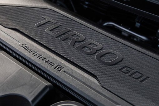 A close-up shot of the turbocharged engine under the hood of the 2026 Kia K4 sedan
